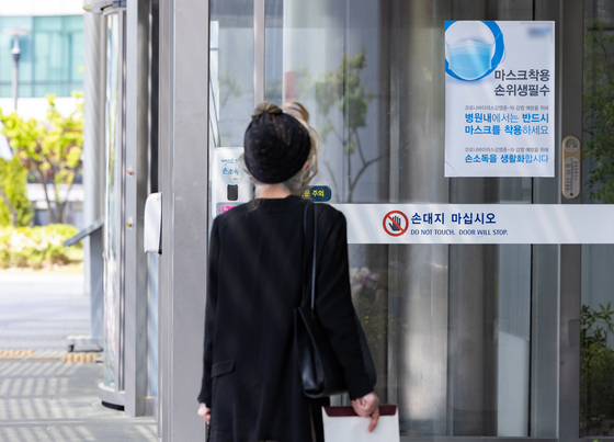 A notice on Covid-19 measures is posted on the entrance of a university hospital in Seoul on Wednesday. Visitors and staffers at hospitals and other health care facilities will not be required to wear face masks starting Wednesday as most remaining Covid-19 restrictions were lifted. [NEWS1]