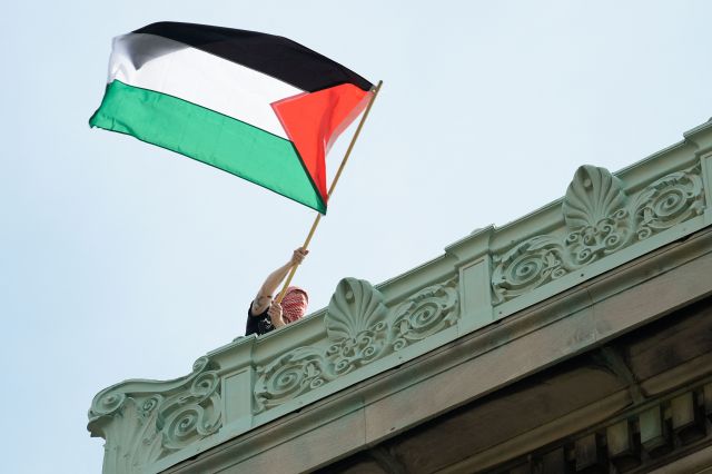 친팔레스타인 시위대 중 한 명이 30일(현지시간) 바리케이드를 치고 점거한 미국 뉴욕주 컬럼비아대 해밀턴홀 옥상에서 팔레스타인 국기를 흔들고 있다. AFP연합뉴스