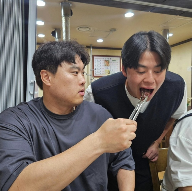 류현진(왼쪽)이 4월 30일 대전 SSG전에서 KBO 리그 통산 100승을 달성한 후 소고기 파티를 열고 노시환에게 직접 한우를 먹이고 있다. /사진=류현진 소속사 99코퍼레이션 제공