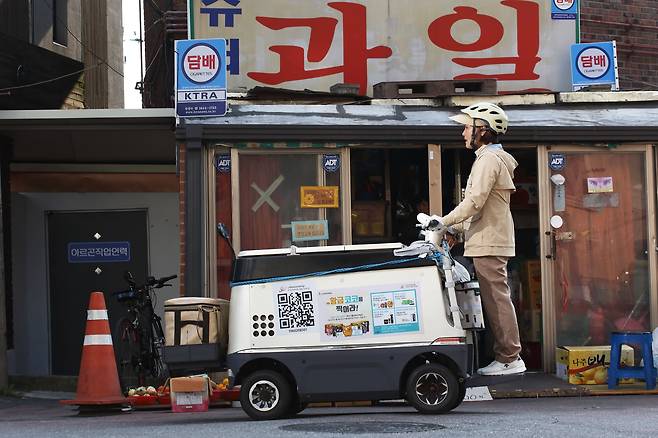 한국 야쿠르트 매니저가 냉장 카트 ‘코코’를 몰고 서울 봉천동 주택가 골목길을 지나고 있다./조선일보 DB