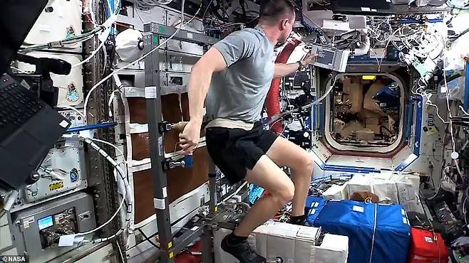 국제우주정거장에서 미국 우주인 앤드루 모건이 몸을 줄로 고정한 상태로 사이클을 타며 유산소 운동을 하고 있다./NASA