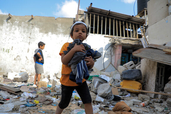 한 팔레스타인 어린이가 1일 가자지구 최남단 라파흐에서 파괴된 주택 내 잔해들 가운데 쓸 만한 물건들을 모으고 있다. 라파흐/신화 연합뉴스