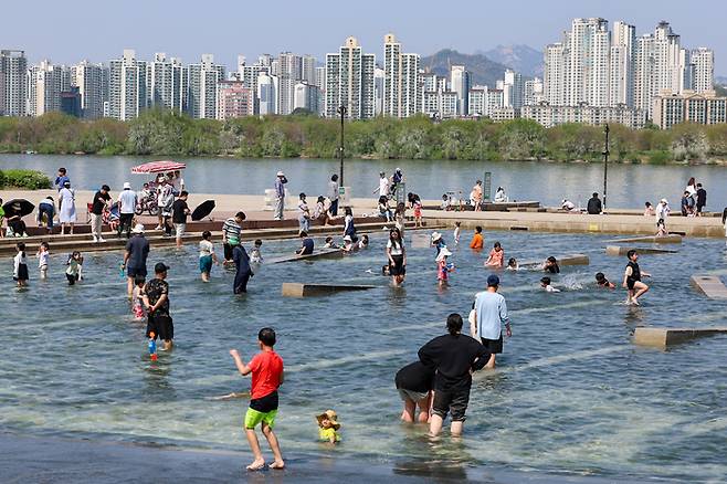 지난달 14일 오후 시민들이 서울 영등포구 여의도한강공원 물빛광장에서 물놀이를 즐기고 있다. [사진 출처 = 연합뉴스]