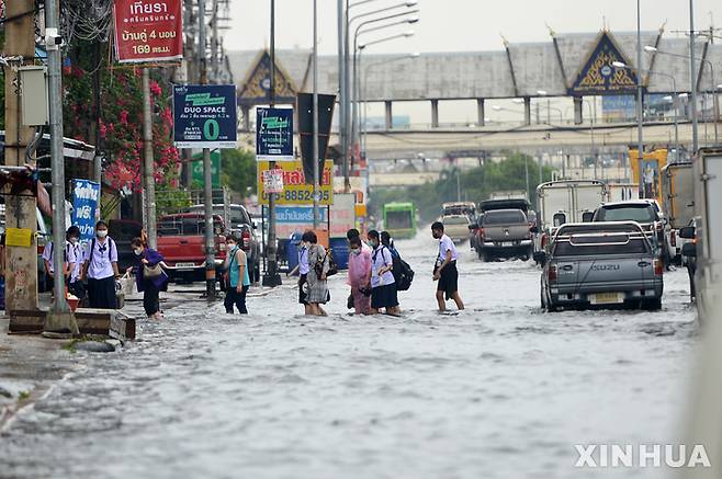 [방콕=신화/뉴시스]일본 정부가 내년부터 인도네시아, 태국, 캄보디아, 베트남 등 동남아 4개국에 위성 데이터를 활용해 호우에 의한 침수 예측을 나타내는 '수해리스크 지도'를 제공한다. 사진은 2022년 9월 태국 방콕에서 시민들이 폭우로 침수된 도로를 건너는 모습. 2024.05.02.