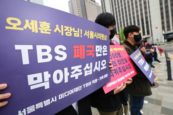 지난달 22일 오후 서울 중구 서울시의회 본관 앞에서 TBS 직원들이 팻말을 들고 있다. 〈사진=연합뉴스〉