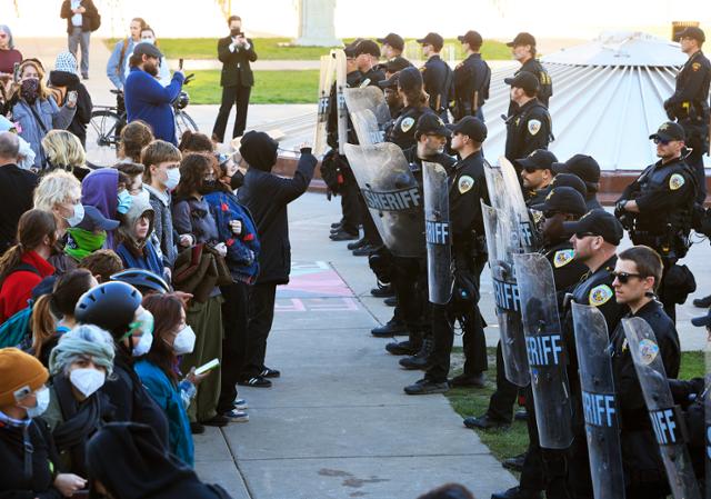 가자지구 전쟁에 반대하는 미국 위스콘신대 학생 시위대가 1일 위스콘신주 매디슨에 위치한 학교 캠퍼스 내에서 경찰 진압조와 대치하고 있다. 매디슨=AP 연합뉴스