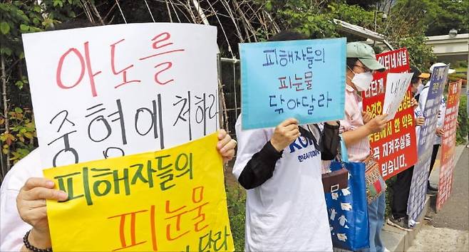 지난달 30일 ‘아도인터내셔널’ 다단계 사기 피해자들이 서울 서초동 서울중앙지방법원 정문 앞에서 시위하고 있다.  /강은구 기자