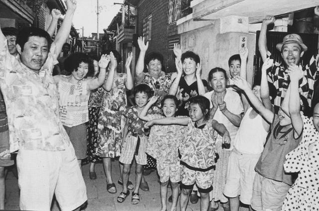 첫 금메달을 딴 여갑순의 이웃 주민들이 만세를 부르고 있다. 한국일보 자료사진