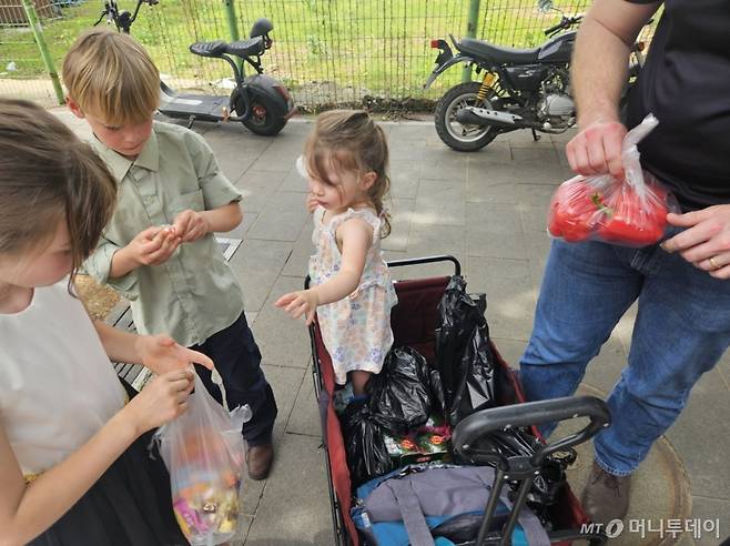 트래비스 벨로브라지드 대위(33)가 지난 28일 오전 경기 평택 안정리로데오 거리 오일장에서 산 물건들을 보여주고 있다. 그는 이날 가족들과 파프리카, 사탕, 멜론 등을 샀다. /사진=정세진 기자