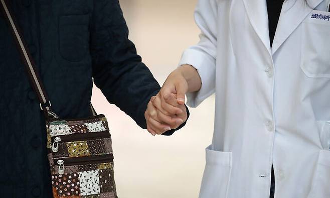 한 대형병원 의료진이 환자의 손을 잡고 걸어가고 있다. 뉴스1