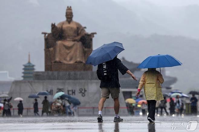 어린이 날을 맞은 5일 서울 종로구 광화문광장에서 우산을 쓴 가족 나들이객이 쏟아지는 빗속에 걸음을 옮기고 있다. 2024.5.5/뉴스1 ⓒ News1 민경석 기자
