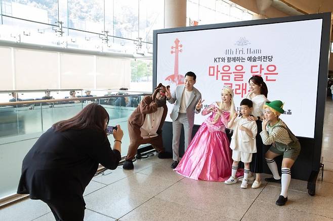 KT 임직원 가족들이 지난 4일 서울 서초구 예술의전당에서 열린 '마음을 담은 클래식 콘서트'에 참여해 기념촬영을 하고 있다. KT 제공