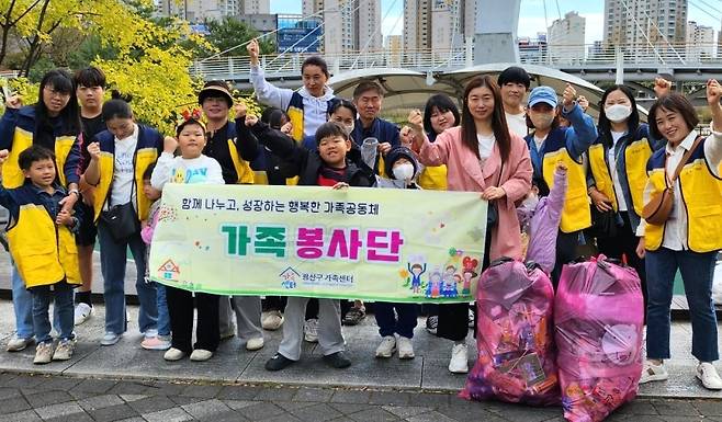▲광산가족센터가 주최한 '가족봉사단' 활동에 참가한 시민들이 자녀들과 함께 파이팅을 외치고 있다