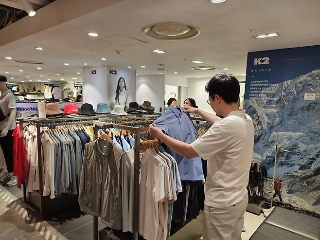 5일 서울 롯데백화점 본점 영플라자 K2 매장에서 한 고객이 냉감 티셔츠를 살펴보고 있는 모습.