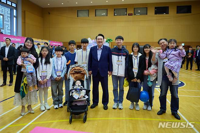 [서울=뉴시스]윤석열 대통령이 5일 청와대 연무관에서 열린 제102회 어린이날 초청행사에서 박성용씨와 이계정씨 부부의 10남매 아이들과 기념촬영을 하고 있다. (사진=대통령실 제공) 2024.05.05. photo@newsis.com