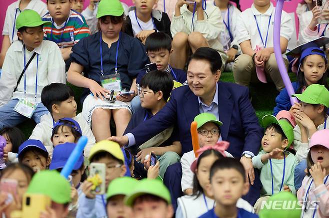 [서울=뉴시스]윤석열 대통령이 5일 청와대 연무관에서 열린 제102회 어린이날 초청행사에서 버블 매직쇼 관람을 위해 자리에 착석 후 어린이들과 인사하고 있다. (사진=대통령실 제공)  2024.05.05. photo@newsis.com