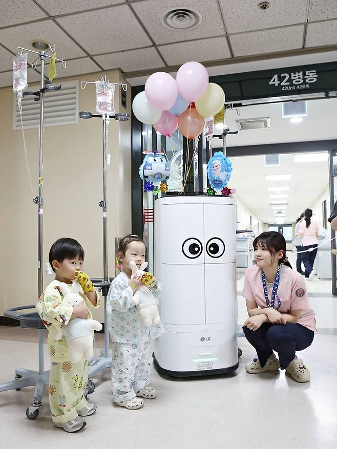 지난 3일 한림대성심병원에서 의료서비스 로봇이 나눠준 어린이날 선물을 받은 소아병동 환자들이 활짝 웃고 있다. 한림대성심병원 제공