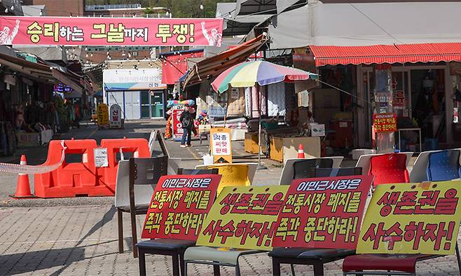안산시 단원구 안산시민시장 주차장 및 입구에 상인회가 놓은 전통시장 폐지 항의 피켓과 현수막이 있다.