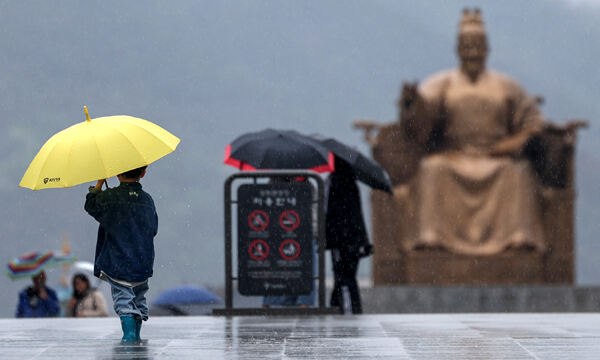 서울 종로구 광화문광장에서 우산을 쓴 한 어린이가 쏟아지는 빗속에 걸음을 옮기고 있다. 뉴스1
