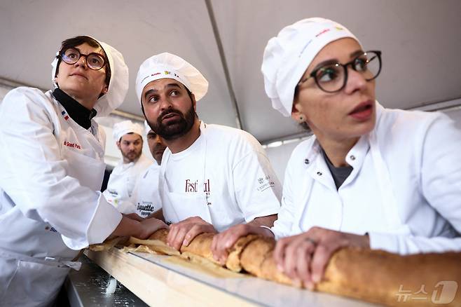 5일(현지시간) 프랑스 파리 근교 쉬렌에서 제빵사들이 세계에서 가장 긴 바게트 기록을 경신하기 위해 대형 회전 오븐에서 바게트를 나르고 있다. 2024.05.05 ⓒ 로이터=뉴스1 ⓒ News1 권진영 기자