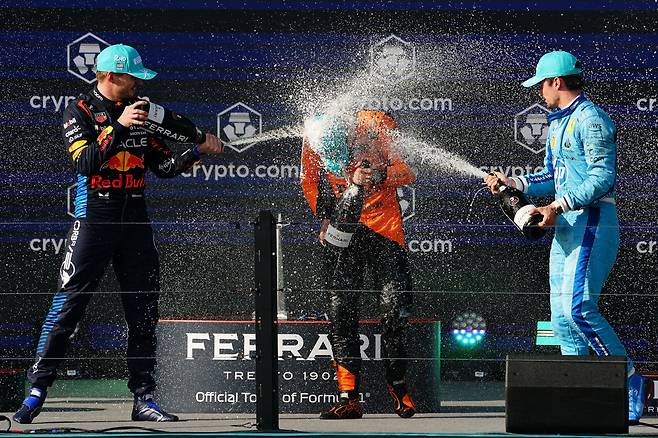 6일 F1 마이애미 그랑프리에서 우승한 랜도 노리스(가운데)가 2위 막스 페르스타펀(왼쪽)과 3위 샤를 르끌레르로부터 샴페인 세례를 받고 있다. /USA투데이 연합뉴스