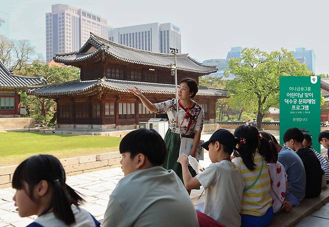 덕수궁 역사교육 문화체험 프로그램에 참여한 아동들이 역사해설가의 설명을 들으며 문화재를 관람하고 있다.