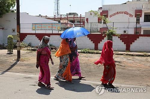 4월 26일 인도 우타르프라데시에서 양산을 쓰고 투표장을 떠나는 여성 유권자들.  [로이터 연합뉴스 자료사진. 재판매 및 DB 금지]