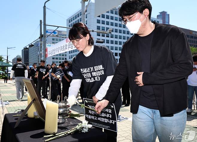 대구전세사기피해대책위원회 등 전세사기 피해자들이 8일 서울 여의도 국회 앞에서 열린 '여덟번째 전세사기 희생자 추모 및 대책마련 촉구 기자회견'에서 피해자를 추모하며 헌화하고 있다. 2024.5.8/뉴스1 ⓒ News1 구윤성 기자