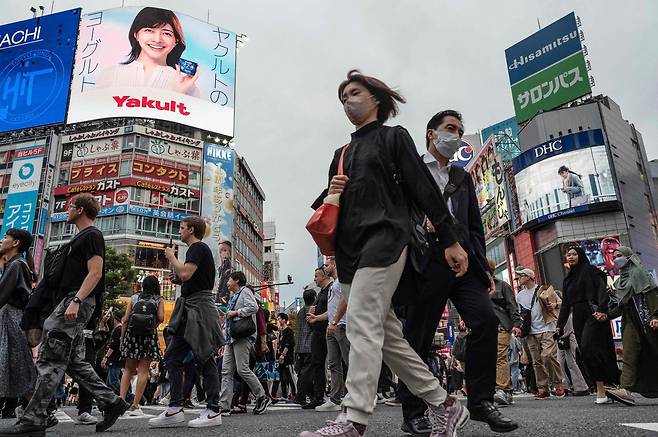 도쿄 시부야 거리에서 시민들이 길을 건너고 있다. /AFP