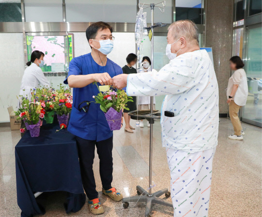 박재형(왼쪽) 충남대병원 노인보건의료센터장이 8일 어버이날을 맞아 입원 환자에게 카네이션을 전달했다. 병원 제공