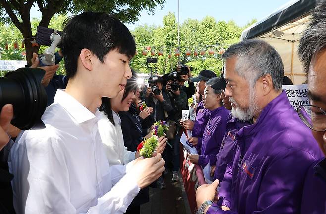 청년들이 유가족들에게 카네이션을 달아주고 있다. 신소영 기자