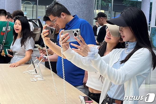 중국 선전시 화웨이 플래그십 매장에서 18일 고객들이 이날 첫 판매를 시작한 화화웨이 새 프리미엄 시리즈 '퓨라70' 스마트폰을 살펴보고 있다, 2024.04.18 ⓒ 로이터=뉴스1 ⓒ News1 김성식기자