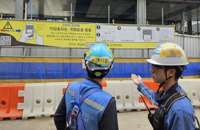 건축 현장에서 근로자들이 작업중지권 현수막을 확인하고 있다. 삼성물산 제공