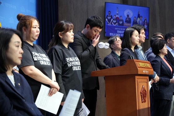 정태운 대구 전세사기 피해대책위 위원장(왼쪽 네번째)이 8일 서울 여의도 국회 소통관에서 열린 기자회견에서 눈물을 훔치고 있다. [뉴시스]