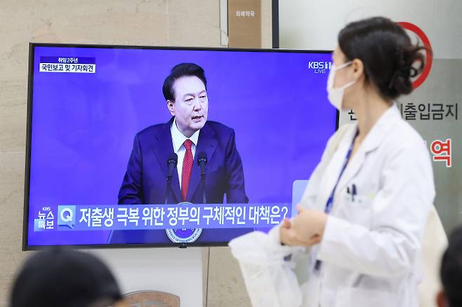 9일 서울 한 대학병원에서 한 의료인이 윤 대통령 기자회견이 생중계되고 있는 텔레비전을 바라보고 있다. 연합뉴스