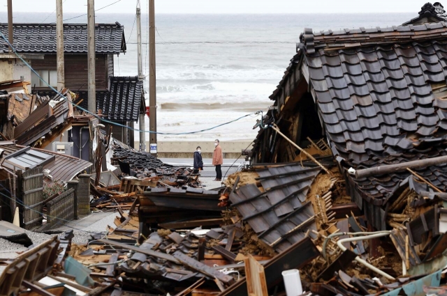 올해 새해 일본 노토반도에서 발생한 규모 7.6의 강진이 발생했다. 지난 1월 일본 주민들이 이시카와현 와지마시에서 무너진 주택을 지켜보고 있는 모습. AP연합뉴스