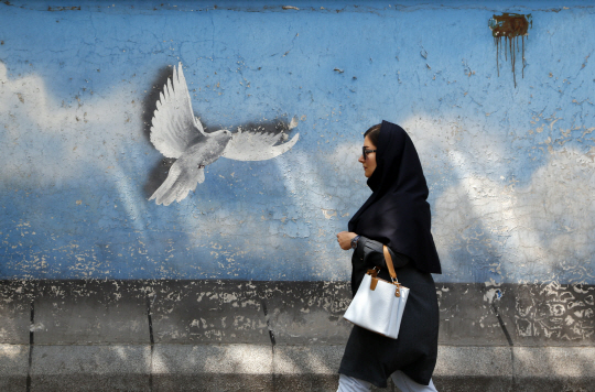 지난달 25일 히잡을 쓰고 이란 수도 테헤란의 한 거리를 지나는 이란 여성. EPA 연합뉴스