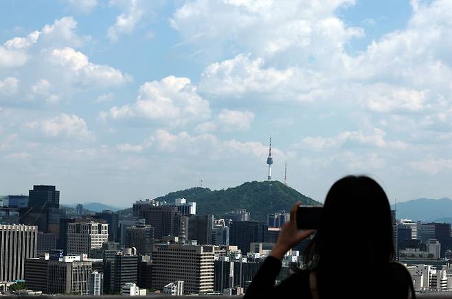 맑은 날씨를 보인 8일 오후 서울 종로구 전망대를 찾은 한 시민이 풍경을 촬영하고 있다. 뉴시스