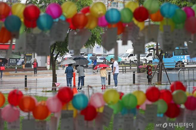 부산 부산진구 송상현광장에 부처님오신날(5월15일)을 맞아 부산연등회가 열리고 있는 가운데 형형색색 소원등 사이로 우산을 쓴 시민들이 지나가는 모습/사진=뉴스1