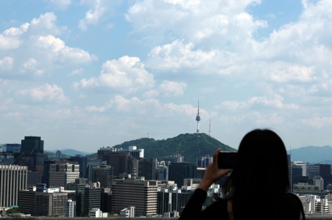 맑은 날씨를 보인 8일 오후 서울 종로구 전망대를 찾은 한 시민이 풍경을 촬영하고 있다. 뉴시스