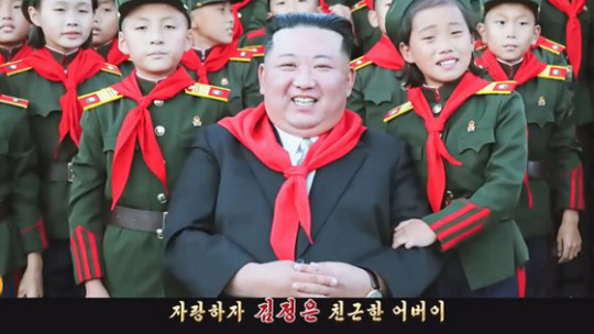 북한이 최근 공개한 뮤직비디오 형식 김정은 찬양 선전 가요 ‘친근한 어버이’의 한 장면. 김정은이 어린 아이들에게 둘러싸여 환히 웃고 있다. 유튜브 ‘메아리’ 캡처