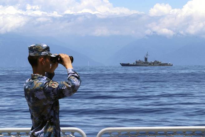 중국과 대만은 대륙 패권을 놓고 1927∼1950년 ‘국공 내전’을 치렀다. 휴전 협정을 맺지 않아 긴장 관계는 계속되고 있다. 중국 인민해방군 병사가 2022년 8월 대만 주변 군사훈련 중 망원경으로 대만 해안선 쪽을 보고 있다. 앞에 보이는 선박은 대만 호위함 란양이다. 신화 뉴시스