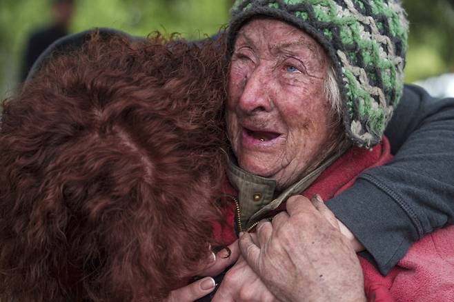 모녀의 눈물 우크라이나 동북부 하르키우주 보우찬스크 마을의 82세 여성이 11일(현지시간) 러시아군의 공습으로 집에서 남편이 숨지자 딸과 함께 대피하면서 울고 있다. AP연합뉴스