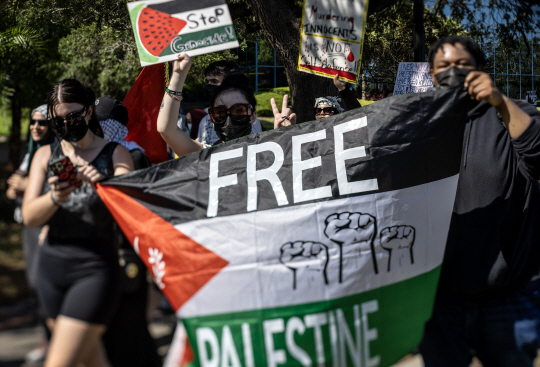 미국 플로리다주 올랜도 시내에서 친팔레스타인 시위대가 ‘팔레스타인에 자유를’이라고 적힌 팔레스타인 국기를 들고 행진하고 있다. EPA 연합뉴스