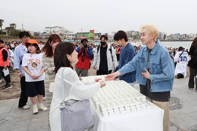 플로깅 참가자에게 기념품을 전달하는 슈퍼주니어 D&E(동해&은혁). 한국관광공사 제공
