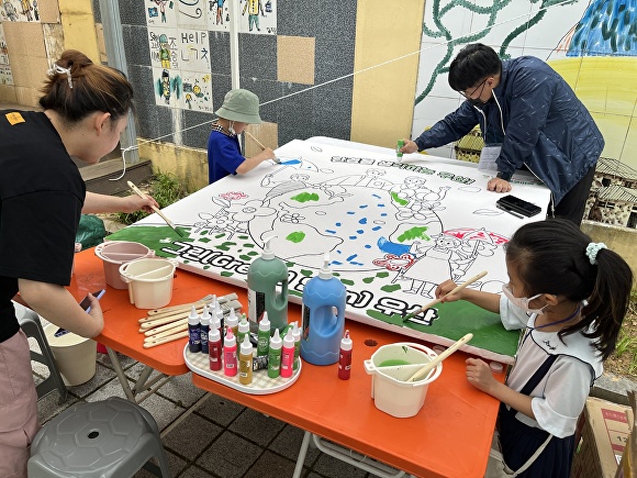 시민들이 '우산동과 환경'을 주제로 밑그림 된 현수막을 색칠하고 있다