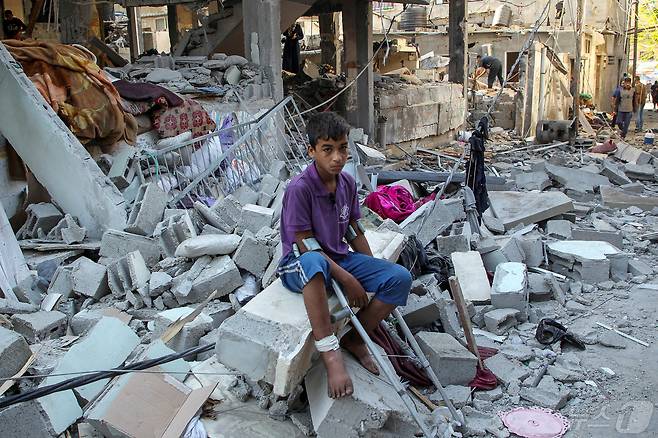 9일(현지시간) 팔레스타인 가자지구 라파에서 한 아이가 이스라엘군의 공습으로 무너진 건물 잔해 위에 앉아있다. 2024.05.09 ⓒ 로이터=뉴스1 ⓒ News1 박재하 기자