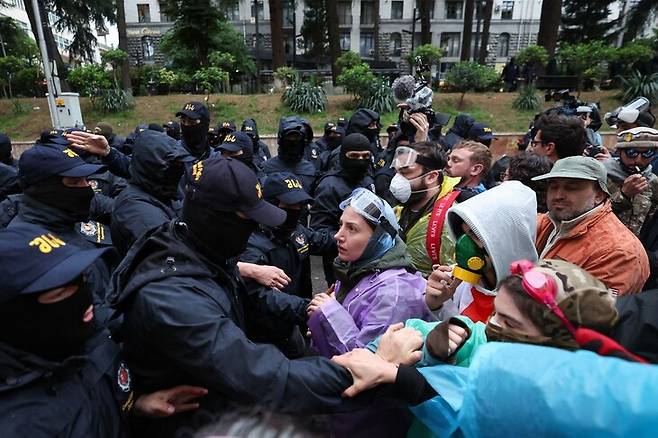 조지아의 언론·시민단체 통제법 제정 반대 시위대가 13일(현지시각) 법안 논의가 예정된 의회 앞에서 시위를 벌이자 경찰들이 막고 있다. 트빌리시/AFP 연합뉴스