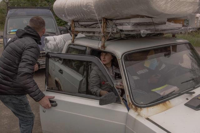 러시아가 진군한 우크라이나 북동부 하르키우에서 공격을 피해 탈출한 주민들이 13일 하르키우 외곽에 있는 검문소에서 대기하고 있다. 하르키우=AFP 연합뉴스