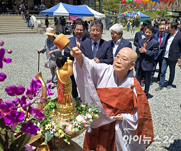 15일 문수사 주지 덕화스님이 봉축 법요식에서 아기 부처의 몸을 물로 씻기는 관불의식을 하고 있다. [사진=이진우 기자]